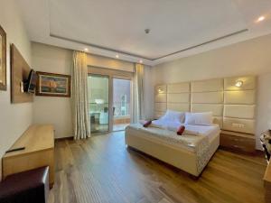 um quarto com uma grande cama branca e uma secretária em Hotel Butua Residence em Budva