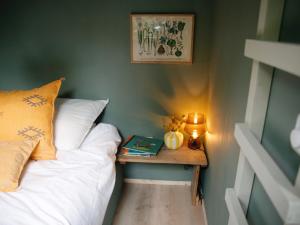 een slaapkamer met een bed en een tafel met een boek bij De Buitenplek van Stek in Nunspeet