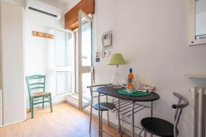 una pequeña mesa y sillas en una habitación con ventana en Bright Studio with terrace & parking, en Bari