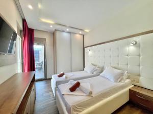 a hotel room with two beds and a television at Hotel Butua Residence in Budva
