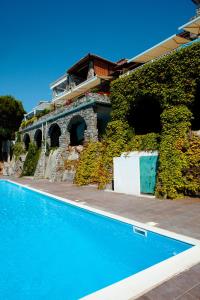 una casa con una piscina azul junto a un edificio en Villa Arianna (Parghelia, Calabria), en Parghelia