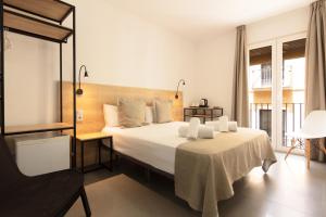 a bedroom with a large bed with white sheets at Hotel La Milagrosa in Alicante