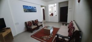 sala de estar con sofá, sillas y mesa en Chandralok Homestay en Kolhapur