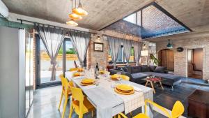 a dining room and living room with a table and yellow chairs at Villa Baraka in Kanfanar