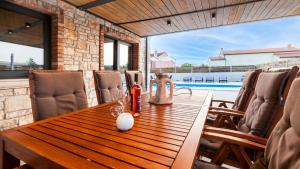 a dining room with a wooden table and a pool at Villa Baraka in Kanfanar