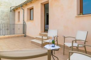 a patio with chairs and a bottle of wine at Villa Placeta in Sa Pobla