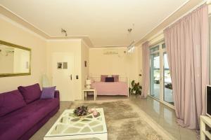 sala de estar con sofá púrpura y cama en Apartments Villa Graf en Smederevo