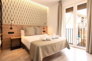 a bedroom with a bed and a large window at Hotel La Milagrosa in Alicante
