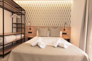 a bedroom with a large bed with white pillows at Hotel La Milagrosa in Alicante