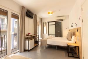 a hotel room with a bed and a television at Hotel La Milagrosa in Alicante