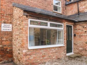 a brick building with a window with a plant in it at Kilderkin in Bedale