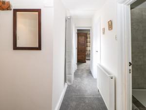 a hallway with white walls and a mirror at Kilderkin in Bedale +17 photos