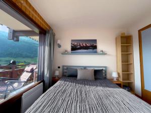 - une chambre avec un lit et une grande fenêtre dans l'établissement Grand-Bo: joli appartement sur les pistes avec vue, au Grand-Bornand