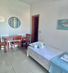 1 dormitorio con 1 cama, mesa y sillas en Four S Apartments, en Mykonos ciudad