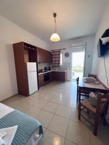 a kitchen with a table and a white refrigerator at Four S Apartments in Mikonos