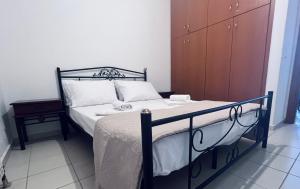 a bedroom with a bed with a wooden cabinet at Four S Apartments in Mikonos +2 photos