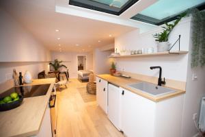 a kitchen with a sink and a living room at Chorlton Stylish Studio & Roof Terrace Apartments in Manchester