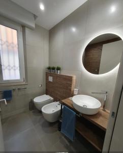 ein Badezimmer mit 2 WCs, einem Waschbecken und einem Spiegel in der Unterkunft Playa degli Angeli Ponente in Gabicce Mare