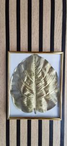 a picture of a leaf in a gold frame at La Maison de Jardin in Lucca