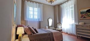 een slaapkamer met een bed, een dressoir en ramen bij La Maison de Jardin in Lucca