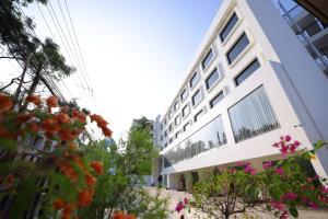 um edifício branco com flores em frente em KKM INTERNATIONAL em Trivandrum