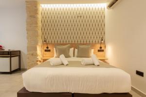 a bedroom with a large white bed with two pillows at Hotel La Milagrosa in Alicante