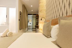 a bedroom with a large white bed with pillows at Hotel La Milagrosa in Alicante