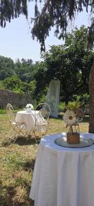 een tafel met een wit tafelkleed en een tafel met stoelen bij La Maison de Jardin in Lucca