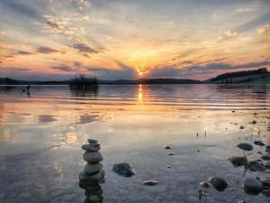 una pila de rocas sentadas en el agua al atardecer en Au Repos, en Tréziers