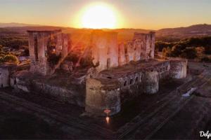 un antiguo castillo con la puesta de sol en el fondo en Au Repos, en Tréziers