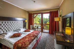 a hotel room with a bed and a balcony at Erdőspuszta Club Hotel Fenyves in Debrecen