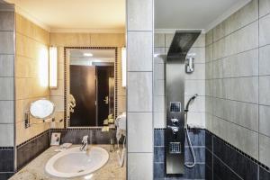 uma casa de banho com um lavatório e um chuveiro em Erdőspuszta Club Hotel Fenyves em Debrecen