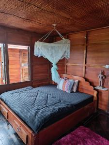 een slaapkamer met een bed met een klamboe bij Meta Homestay in Phumĭ Puŏk Chăs