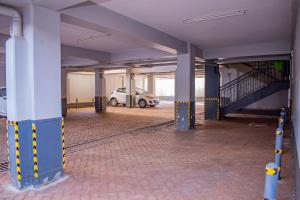 un garage vide avec une voiture garée à l'intérieur dans l'établissement Belaire BnB Ruaka 3, à Ruaka