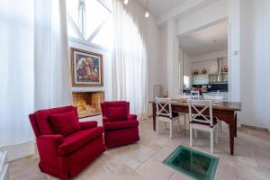 un soggiorno con tavolo e 2 sedie rosse di Villa Minioti Apartment C ad Arnesano