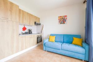 a blue couch in a kitchen with yellow pillows at La Casa de Franck in Linguizzetta