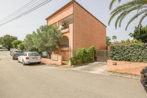 a building with cars parked on the side of a street at La Casa de Franck in Linguizzetta