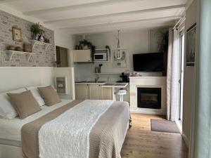 a bedroom with a large bed and a kitchen at Beach Holiday Appartements in Dirkshorn