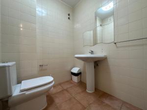 a white bathroom with a toilet and a sink at Golf and Beach Serenity in Aroeira +26 photos