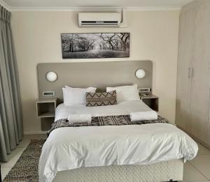 een slaapkamer met een groot bed met een witte sprei bij Cape Town Beachfront Accommodation in Blouberg in Bloubergstrand