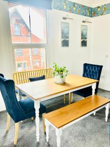 a dining room with a wooden table and chairs at Paradise St Apartment Middle Floor 1 flight of stairs 3 bed 1 bathroom in Rhyl