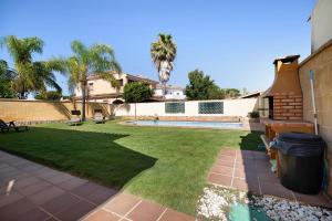 einen Hof mit einem Pool und einem Haus in der Unterkunft Chalet con piscina en la Barrosa in Chiclana de la Frontera