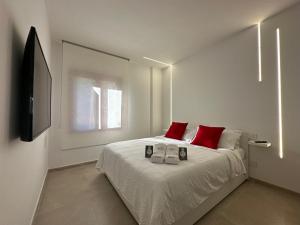 een slaapkamer met een bed met rode kussens en een televisie bij Shin in Budoni