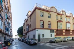 a building on a street with cars parked in front of it at Victoria's Apartamentos in Málaga