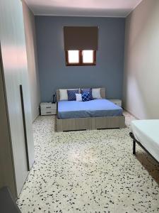 una camera con letto e parete blu di Sisters appartamenti a Castelvetrano Selinunte