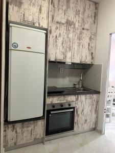 a kitchen with a white refrigerator and a sink at Greek Escape in Paleo Tsifliki