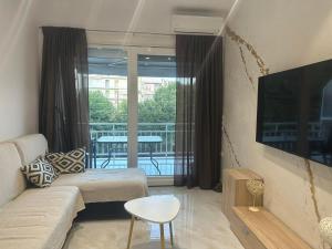 a living room with a couch and a view of a balcony at Greek Escape in Paleo Tsifliki
