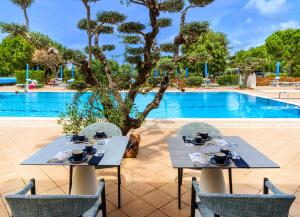 two tables and chairs in front of a pool at San Francesco Country Resort in Vada
