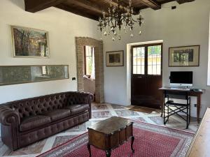 sala de estar con sofá de cuero y mesa en Cadepaoli Vineyard & Roses - Bergamo Countryside, en Palosco