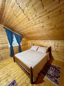 ein Schlafzimmer mit einem Bett in einem Holzzimmer in der Unterkunft Guesthouse Zgiboza in Shkodra